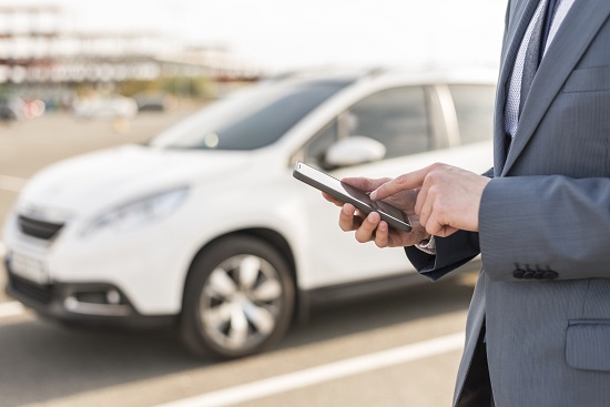 businessman with smartphone front car resized
