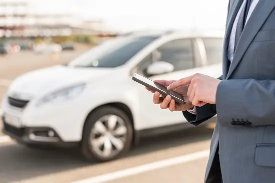 businessman-with-smartphone-front-car-resized